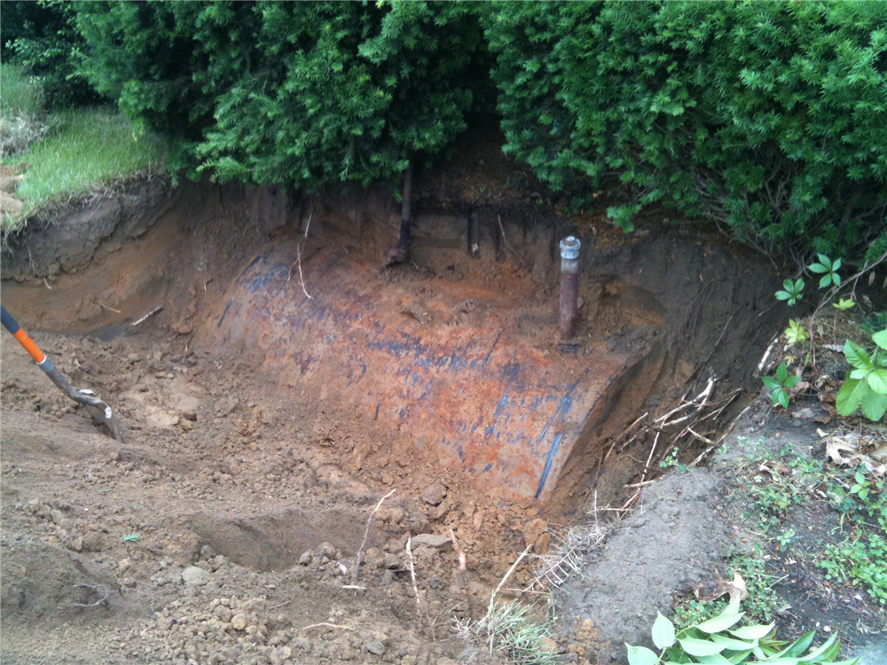Buried oil tank uncovered prior to cleaning.